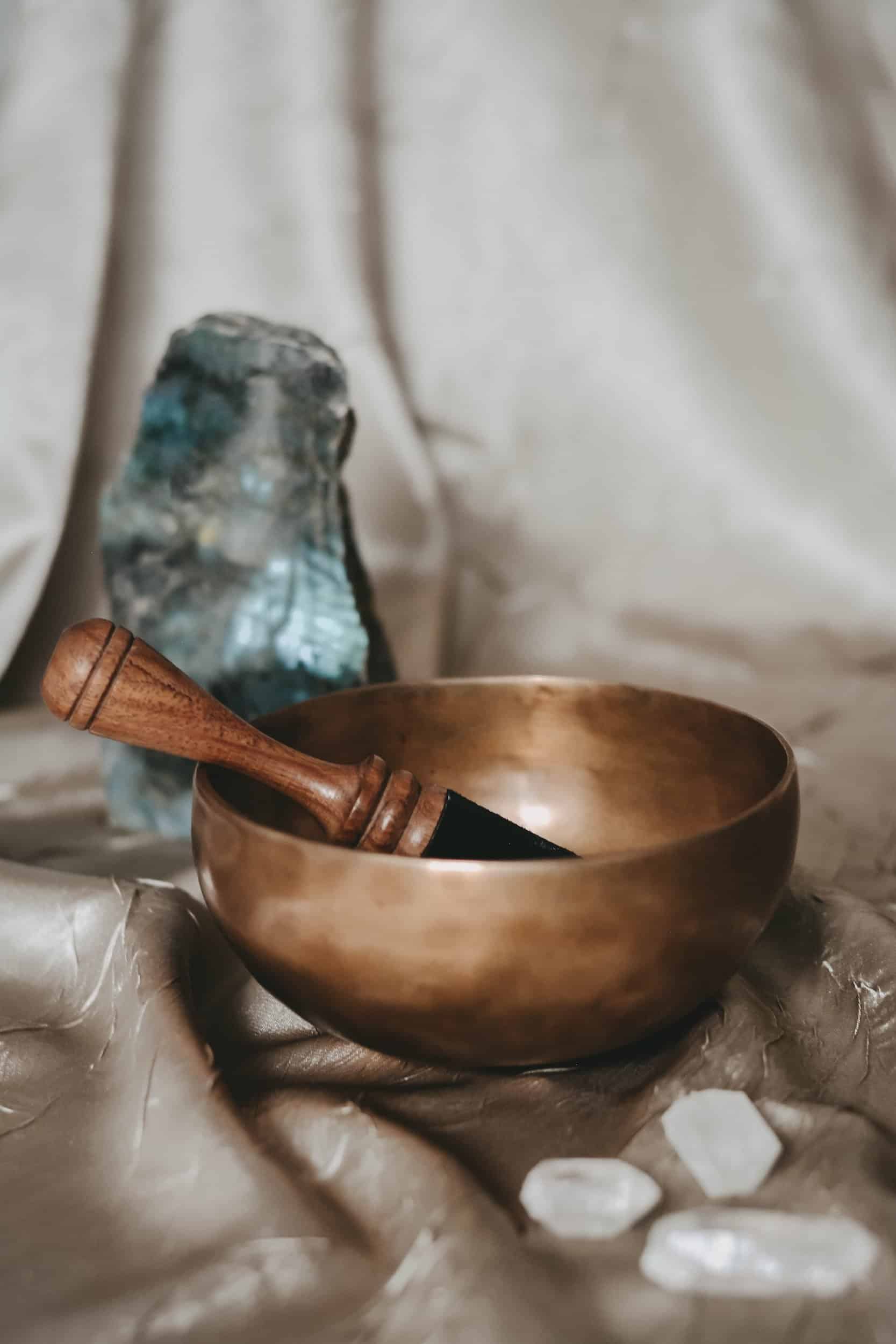 Gold singing bowl next to blue crystal